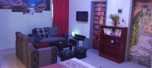 a living room with a chair and a television at Agreable Studio Meuble in Abidjan