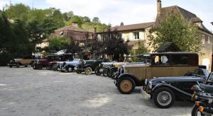 a row of old cars parked in a parking lot at Hôtel Auberge de La Nauze in Sagelat