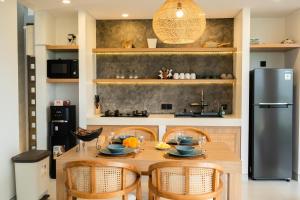 a kitchen with a wooden table with chairs and a refrigerator at Mountain Sunshine Private Villa in Darmasaba