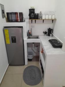 a small kitchen with a sink and a refrigerator at Perfect Getaway #1 in La Libertad