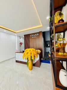 a room with a vase with yellow flowers in it at Amazon Hotel in Phước Hậu (1)