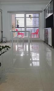 a dining room with a white table and red chairs at 3bhk Near kodapur-Hitex Exhibition&Shilparamam Art in Hyderabad
