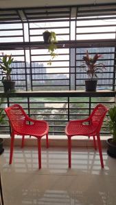 two red chairs sitting in front of a window at 3bhk Near kodapur-Hitex Exhibition&Shilparamam Art in Hyderabad