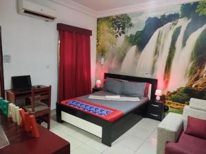 a bedroom with a bed with a painting on the wall at Agreable Studio Meuble in Abidjan