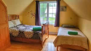 a bedroom with a twin bed and a window at Domaine des sentiers in Mansonville