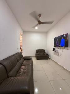 a living room with a couch and a flat screen tv at Teratak Shamar in Kampong Tebok Pulai