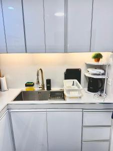 a kitchen with white cabinets and a sink and a sink at Gray Room The White Haven In Clark in Angeles