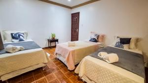 ein Zimmer mit drei Betten in einem Zimmer in der Unterkunft Pousada in Belém + 31 Fotos