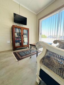 a living room with a bench and a tv at WestBed in Langebaan