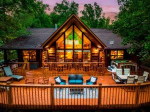 a large house with a deck with chairs and tables at Joy's Retreat Cabin in Sevierville