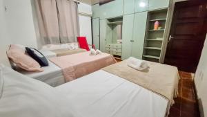 ein Zimmer mit zwei Betten und einem Kleiderschrank in der Unterkunft Pousada in Belém
