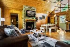 a living room with a couch and a fireplace at Joy's Retreat Cabin in Sevierville
