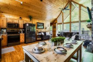 a kitchen and living room with a wooden ceiling at Joy's Retreat Cabin in Sevierville