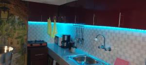 a kitchen with a sink and a blue led lighting at Agreable Studio Meuble in Abidjan