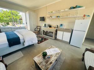 a bedroom with a bed and a table and a kitchen at WestBed in Langebaan