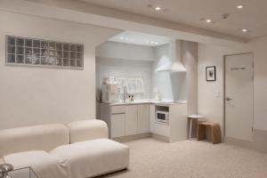 a white living room with a couch and a kitchen at Staymoment in Seoul