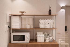 a microwave oven sitting on a shelf with towels at Staymoment in Seoul +66 photos