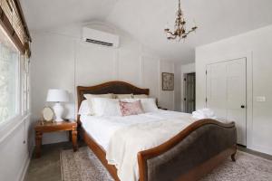 a bedroom with a large bed and a chandelier at Honeymoon Cottage Chateau DuMont in Banner Elk +9 photos