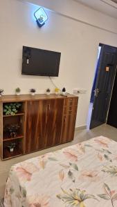 a bedroom with a bed and a flat screen tv on a wall at Urban Cozy 2 bhk in Ghaziabad