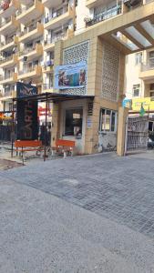 a building with two benches in front of it at Urban Cozy 2 bhk in Ghaziabad