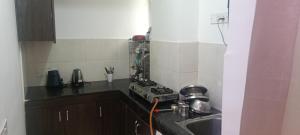 a small kitchen with a sink and a stove at Urban Cozy 2 bhk in Ghaziabad