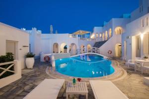 a villa with a swimming pool at night at Kanale's Rooms & Suites in Naousa