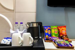 a kitchen counter with a coffee maker and some snacks at Hotel Bella Express in New Delhi