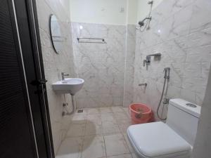 a bathroom with a toilet and a sink at Gold Mountain Wellness Resort in Tiruvannāmalai +33 photos