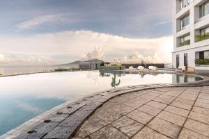 a swimming pool in front of a building at Aryaduta Manado in Manado