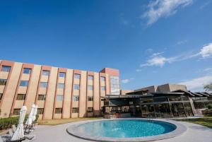 a building with a swimming pool in front of a building at Hotel Agua del Desierto in Calama