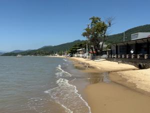 a beach with water and a building on it at Loft novo e bem localizado in Biguaçu