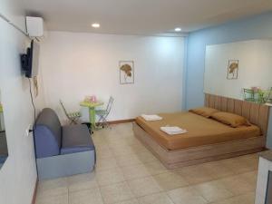 a bedroom with a bed and a blue chair at แฟนตาซีรีสอร์ท สระบุรี in Ban Khok Sawang (1)
