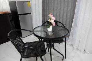 a table with two chairs and a vase with flowers on it at San Cristóbal Surf House II in San Cristóbal