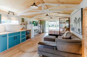 a kitchen and living room with blue cabinets and a couch at Mangapiko Cabin in Pirongia