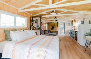 a bedroom with a large bed and a kitchen at Mangapiko Cabin in Pirongia