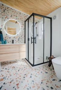 a bathroom with a shower and a mirror at Mangapiko Cabin in Pirongia