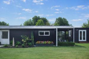a black tiny house with a yard at Mangapiko Cabin in Pirongia