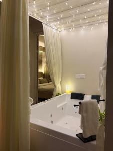 a bathroom with a tub with lights on the ceiling at Chérie Bliss Loft in Jaipur