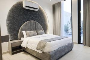 a bedroom with a large bed with a wall at Amora Villa in Al Rama +28 photos