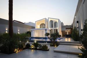 a villa with a swimming pool and a building at Amora Villa in Al Rama
