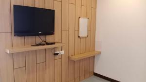 a flat screen tv on a wall with a shelf at แฟนตาซีรีสอร์ท สระบุรี in Ban Khok Sawang (1) +8 photos