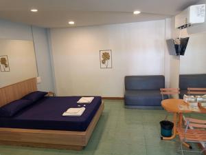 a room with a bed and a chair and a table at แฟนตาซีรีสอร์ท สระบุรี in Ban Khok Sawang (1)