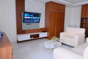 a living room with a white couch and a tv at Grand Elhajj Banten in Tjipondoh Tiga