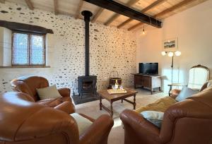 a living room with leather furniture and a fireplace at Lo casalar in Noguères