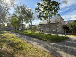 an old stone house with trees on the side of a road at Lo casalar in Noguères