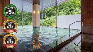 a pool of water in a building with windows at KAMENOI HOTEL Aomori Makado in Noheji