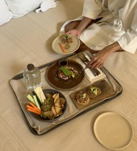 ein Tablett mit Essen auf einem Tisch mit einem Teller mit Essen in der Unterkunft Casona Sforza in Puerto Escondido + 29 Fotos