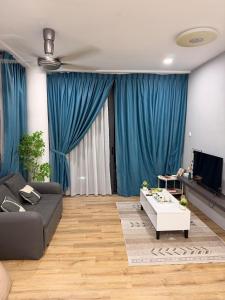 a living room with blue curtains and a couch at Hann's Residence Your second home in Sibu