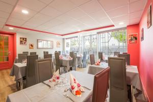 un restaurante con mesas, sillas y paredes rojas en Hôtel des voyageurs, en Saint-Paulien