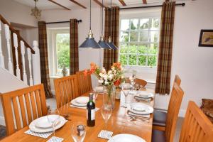a dining room with a wooden table with flowers on it at 5 Bed in Wath oc-w28415 in Wath